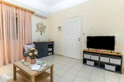 a living room with a television and a table at Orchid - Stylish Home Near Piraeus in Piraeus
