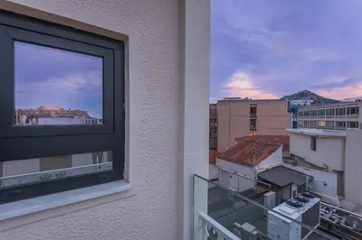 a view of a city from a window at Sofokleous suite with Acropolis stunning view in Athens