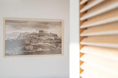 a picture hanging on a wall next to a window at Sofokleous suite with Acropolis stunning view in Athens