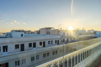 a view of a building with the sun setting behind it at Sofokleous suite with Acropolis stunning view in Athens
