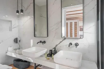a white bathroom with a sink and a mirror at Sofokleous suite with Acropolis stunning view in Athens