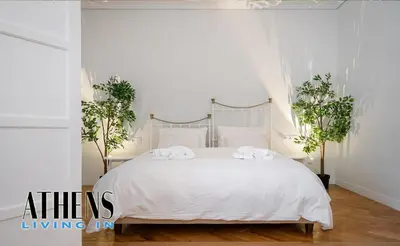 a white bedroom with a white bed with two plants at Classic Studio B1 - 3ppl in Athens