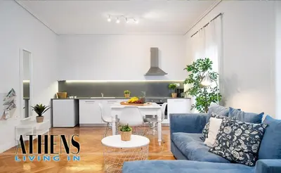 a living room with a blue couch and a kitchen at Classic Studio B1 - 3ppl in Athens