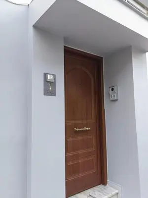 a wooden door in a white wall with a stair case at Modern Niarchos Escape in Athens