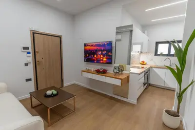 a living room with a couch and a kitchen at Modern Niarchos Escape in Athens