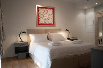 a bedroom with a white bed with two lamps on it at Bright Gem in Vibrant Popular Neighborhood in Athens