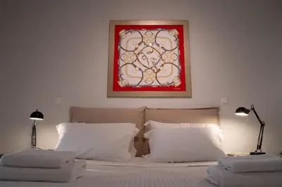 a bedroom with two white pillows and a painting on the wall at Bright Gem in Vibrant Popular Neighborhood in Athens