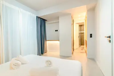 a white bedroom with towels on a bed at Katia's Central 3Bdr 3Bthr Aprt in Athens