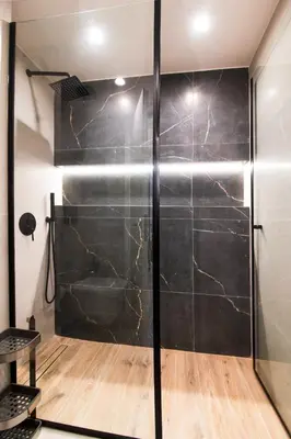 a shower in a bathroom with a black wall at Katia's Central 3Bdr 3Bthr Aprt in Athens