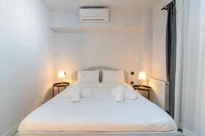 a bedroom with a large white bed with two lamps at Katia's Central 3Bdr 3Bthr Aprt in Athens