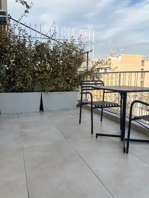 a table and chairs on top of a balcony at Modern Athens Apartment with Large Private Balcony in Athens