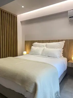 a bedroom with a large bed with white sheets and pillows at Modern Athens Apartment with Large Private Balcony in Athens