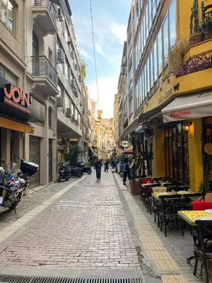 an empty city street with tables and chairs and buildings at Modern Athens Apartment with Large Private Balcony in Athens