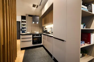 a kitchen with white cabinets and black appliances at Kolonaki Silent Elegance in Athens