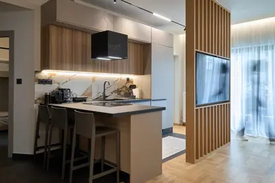 a kitchen with a sink and a bar with stools at Kolonaki Silent Elegance in Athens
