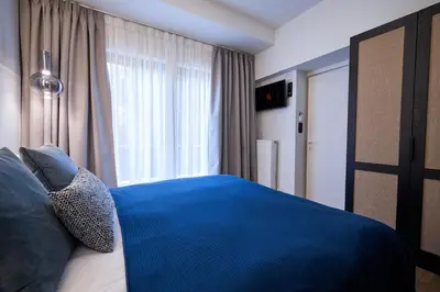 a bedroom with a blue bed with a window at Kolonaki Silent Elegance in Athens
