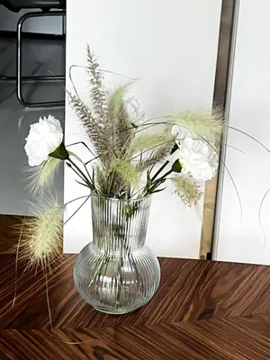 a glass vase with white flowers on a table at Lovely, brand new, central , Modern appt Athenes - Axelle Place in Athens