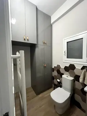 a bathroom with a toilet and a tv on the wall at Lovely, brand new, central , Modern appt Athenes - Axelle Place in Athens