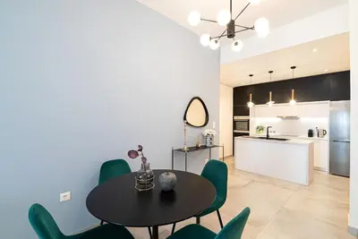 a kitchen and dining room with a table and green chairs at Filoxenia MG Projects Eggeli Athens in Athens