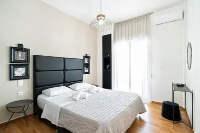 a bedroom with a large bed with a black headboard at Filoxenia MG Projects Eggeli Athens in Athens