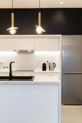 a kitchen with black and white cabinets and stainless steel appliances at Filoxenia MG Projects Eggeli Athens in Athens