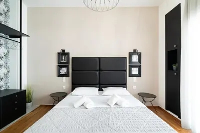 a bedroom with a large bed with a black headboard at Filoxenia MG Projects Eggeli Athens in Athens