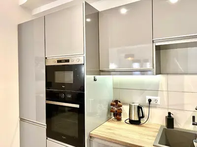 a kitchen with white cabinets and a black appliance at 3BD next to National Archaeological Museum in Athens