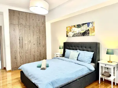 a bedroom with a large bed with blue sheets at 3BD next to National Archaeological Museum in Athens