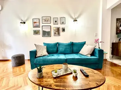 a living room with a blue couch and a table at 3BD next to National Archaeological Museum in Athens