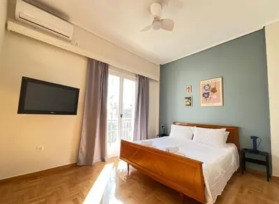 a bedroom with a bed and a flat screen tv at Quiet, Sunny & Terrace with Acropolis View in Athens