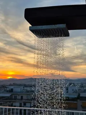 a water fountain with the sunset in the background at Quiet, Sunny & Terrace with Acropolis View in Athens