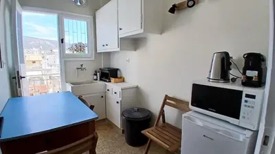a small kitchen with a counter and a microwave at Quiet, Sunny & Terrace with Acropolis View in Athens