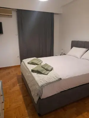 a bedroom with a bed with green towels on it at Alex house Athens in Athens