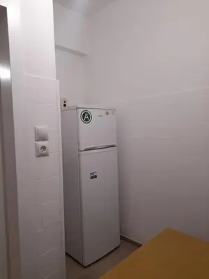 a small white refrigerator in a corner of a room at Alex house Athens in Athens