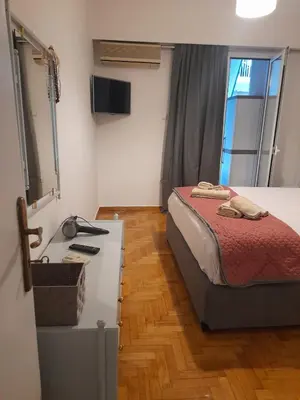 a bedroom with a bed and a desk with a mirror at Alex house Athens in Athens