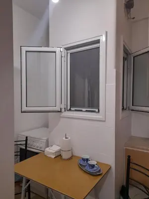a small table in a kitchen with two windows at Alex house Athens in Athens