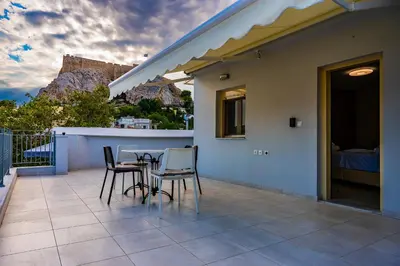 a patio with chairs and a table on a balcony at Elegant Flats in Historic Centre in Athens