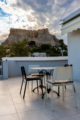 a table and chairs on a balcony with a mountain at Elegant Flats in Historic Centre in Athens