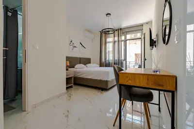 a bedroom with a bed and a desk and a table at Elegant Flats in Historic Centre in Athens