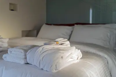 a pile of towels sitting on top of a bed at Breathtaking Penthouse Vouliagmeni in Athens