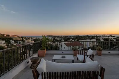 a balcony with couches and a table and a view at Breathtaking Penthouse Vouliagmeni in Athens