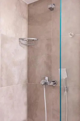 a shower with a glass door in a bathroom at Modern 2-Bedroom Apt in Athens in Athens
