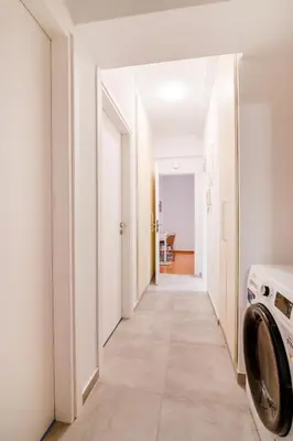 a hallway with a washer and dryer in a house at Modern 2-Bedroom Apt in Athens in Athens