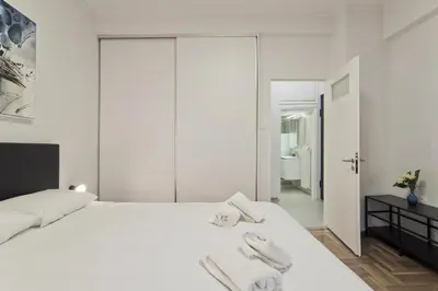 a bedroom with a white bed with towels on it at Serra Relaxing Renovated Apt by Marina & Beach in Piraeus
