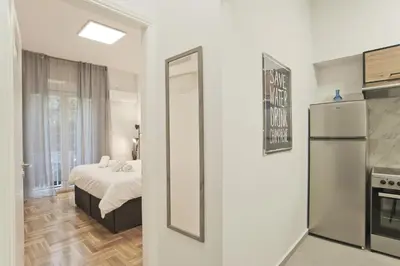 a bedroom with a bed and a mirror and a refrigerator at Serra Relaxing Renovated Apt by Marina & Beach in Piraeus