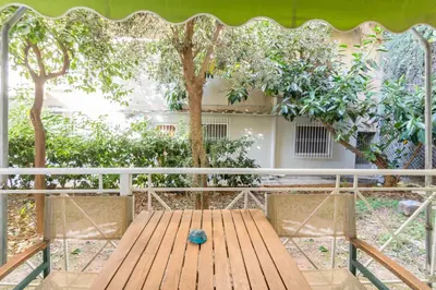a wooden bench on a balcony with a tree at Secret Base In Central Athens in Athens
