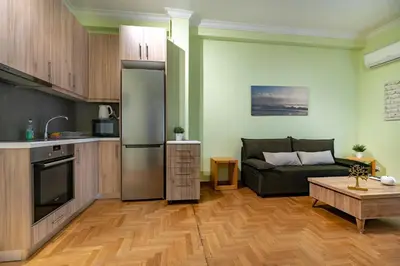 a kitchen and living room with a couch and a table at Central Athens Apt Street View by MPS in Athens