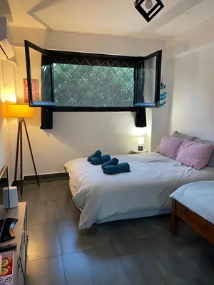 a bedroom with a bed with two blue pillows on it at Chambres Élysées in Athens