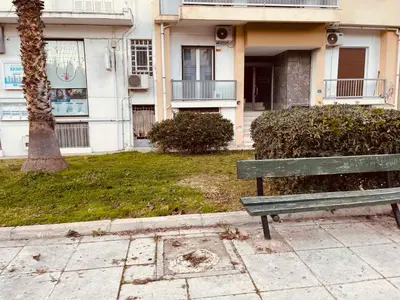 a green park bench sitting in front of a building at Chambres Élysées in Athens