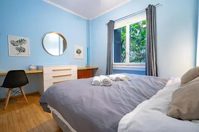 a blue bedroom with a bed with towels on it at Central Athens Apt Patio View by MPS in Athens